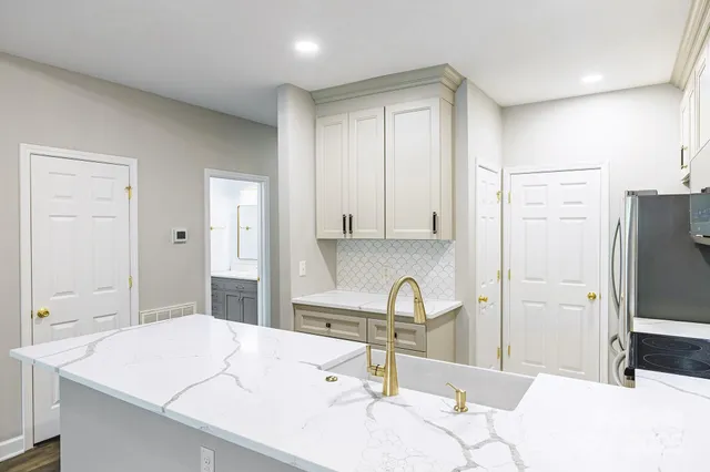 a kitchen with a sink refrigerator and cabinets