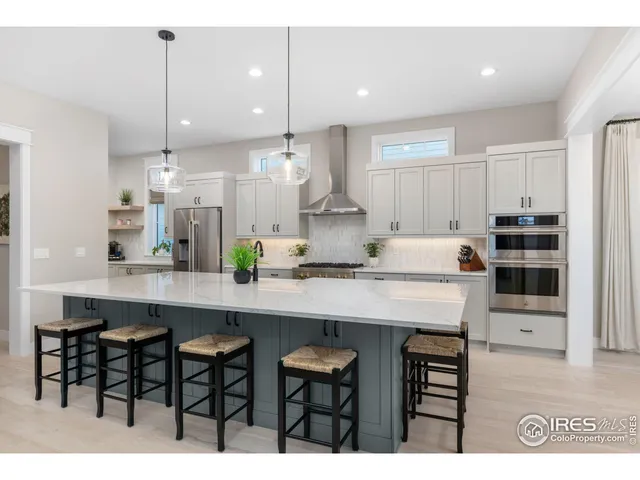 a kitchen with kitchen island granite countertop a sink and chairs