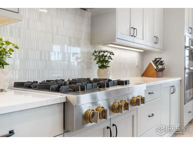 a kitchen with a sink a stove and white cabinets