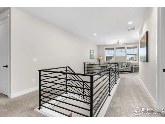 a view of a hallway with wooden floor and furniture
