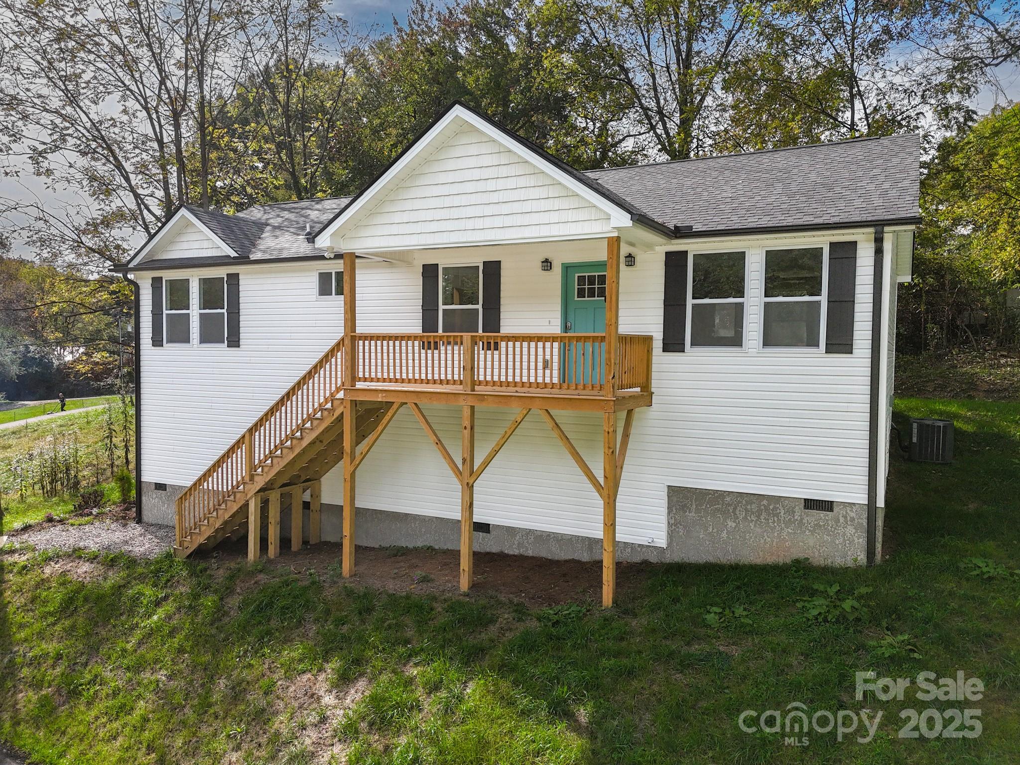 a view of house with a yard and potted plants