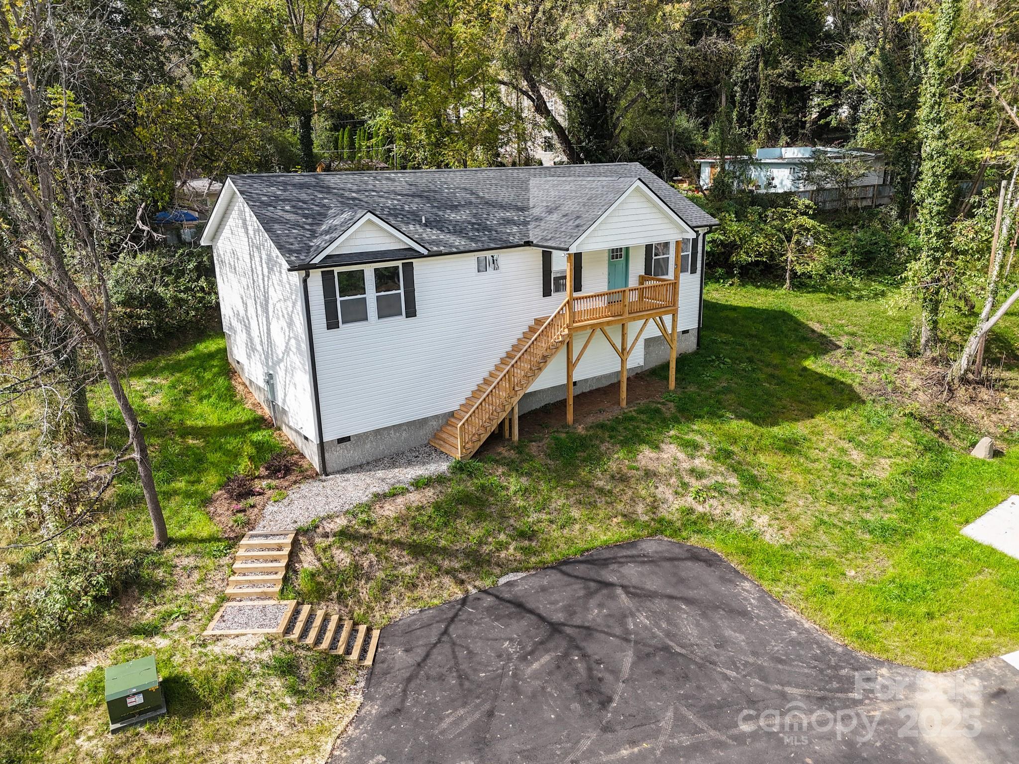 12 Holcombe Road Candler, NC 28715 - Photo 2 of 37 a aerial view of a house with table and chairs in a yard