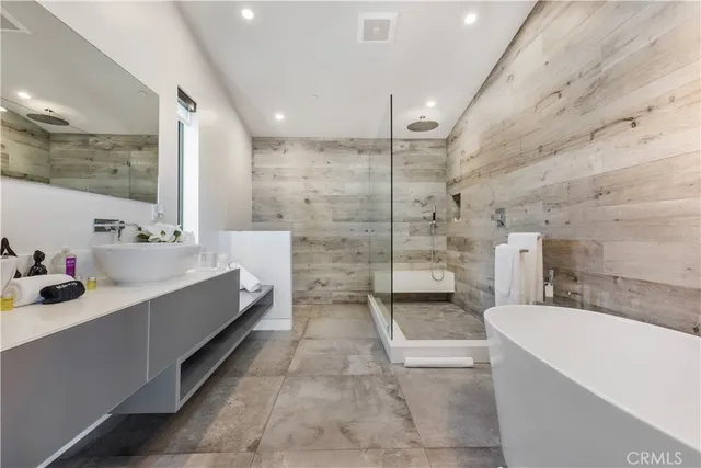 a bathroom with a tub a sink a double vanity and a shower