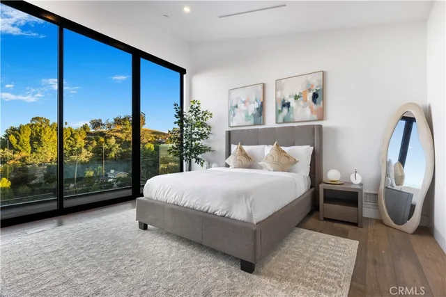 a bedroom with a large bed and a painting on the wall