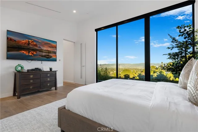 a spacious bedroom with a large bed and a flat screen tv