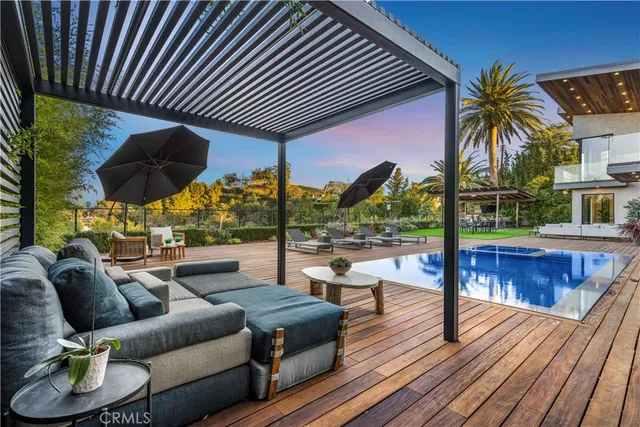a balcony with wooden floor table and chairs