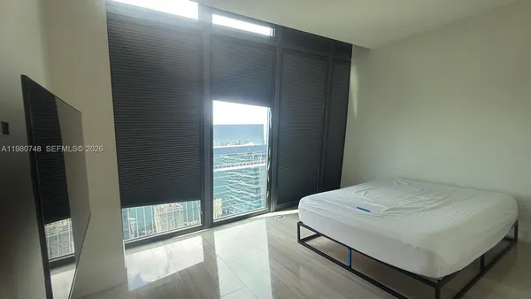 a bedroom with a bed and a large window