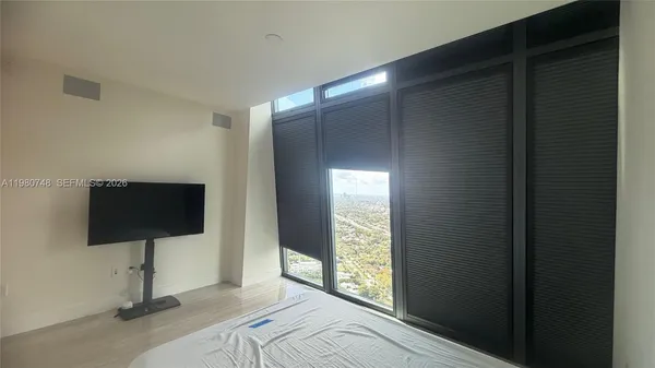 a living room with a flat screen tv and a floor to ceiling window