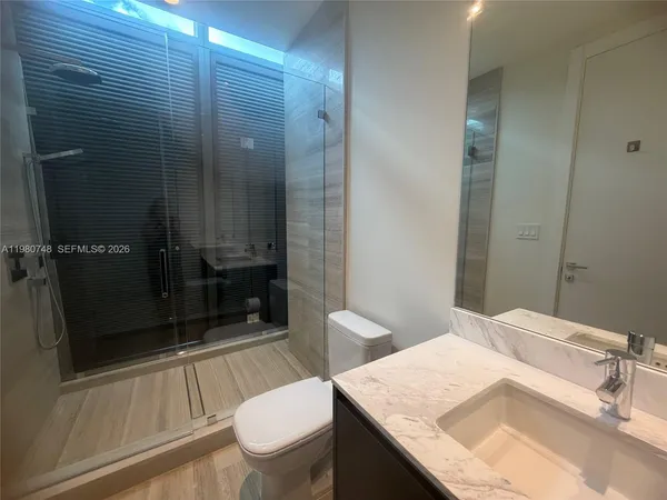 a bathroom with a granite countertop sink toilet and shower