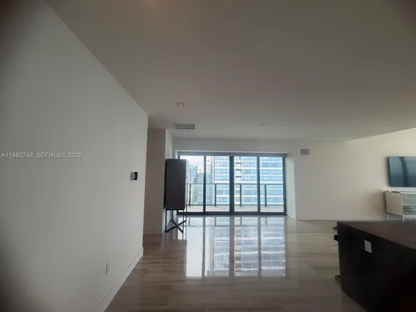 a view of a living room hardwood floor and a window