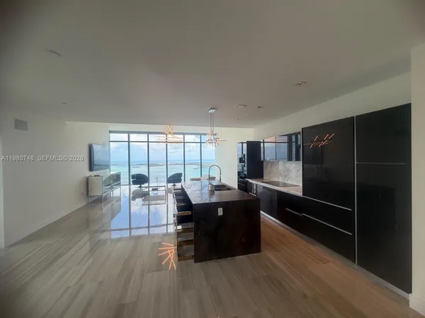 a living room with furniture a large window and wooden floor