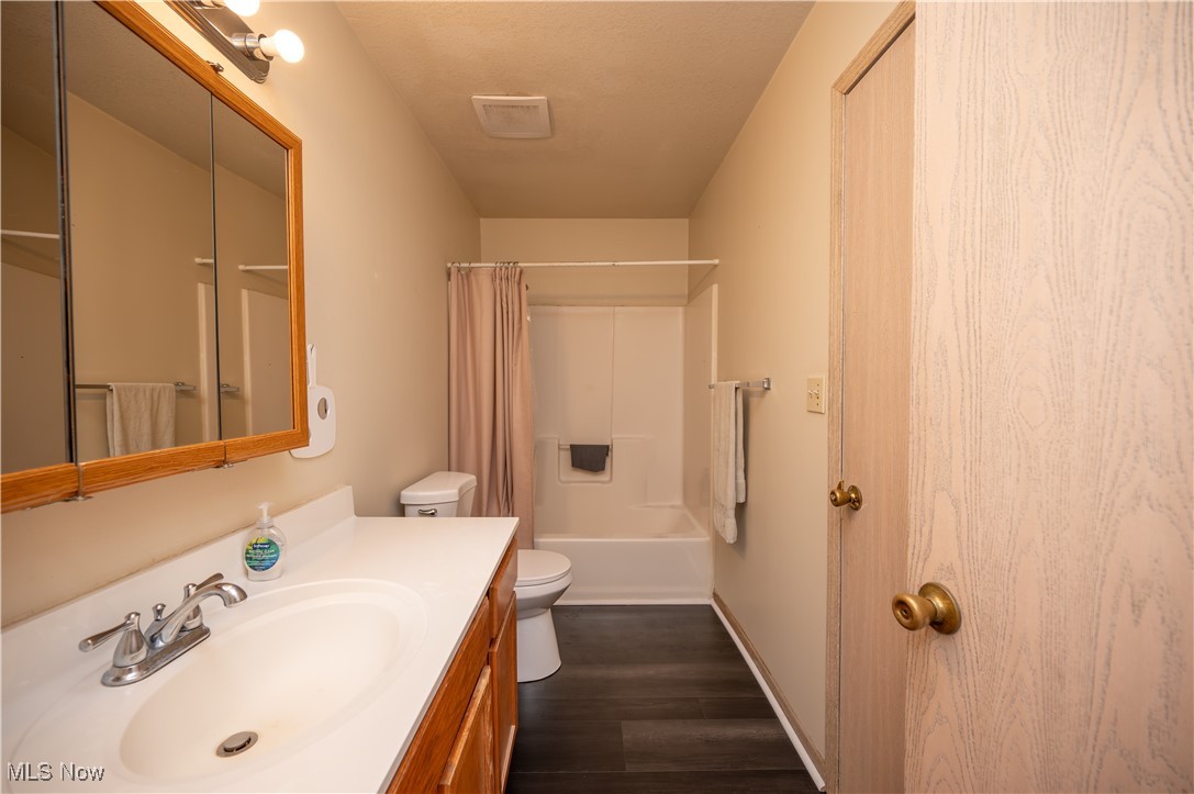 5546 Shaffer Road Northwest, Unit A & B Warren, OH 44481 - Photo 26 of 47 Bathroom with vanity, dark wood-style flooring, and shower / tub combo
