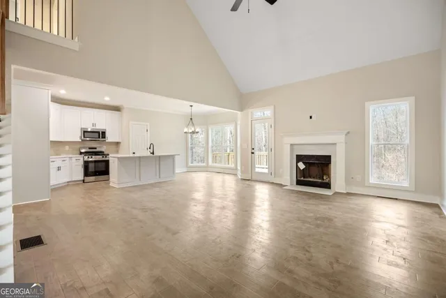 a view of a livingroom with wooden floor and stairs