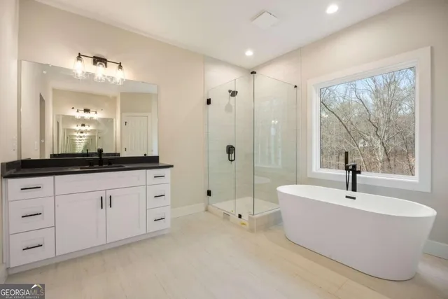 a bathroom with a granite countertop sink a mirror and a shower