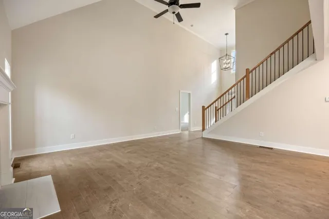 a view of an empty room with wooden floor fireplace and a window
