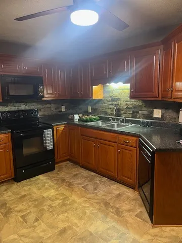 a kitchen with stainless steel appliances granite countertop a stove a sink and a microwave