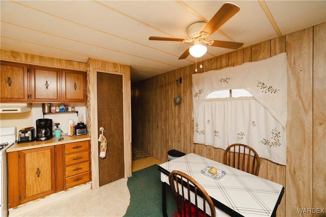 2565 Hopi Road Golden Valley, AZ 86413 - Photo 9 of 40 a kitchen with stainless steel appliances kitchen island granite countertop a refrigerator a sink dishwasher a dining table and chairs with wooden floor