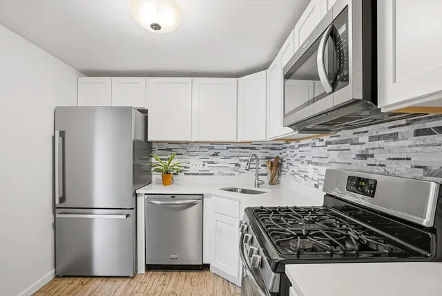 a kitchen with a refrigerator a stove a microwave and cabinets