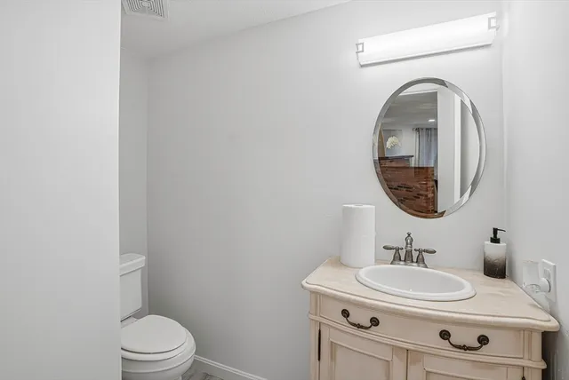 a bathroom with a sink a toilet and a mirror