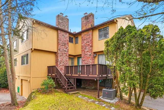 a view of house with a large window and potted plants