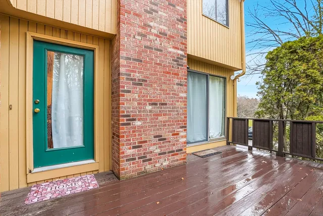 a view of a brick house with a wooden bench