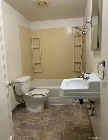 a view of a backyard with wooden fence and a large tree