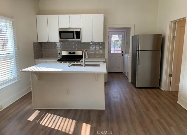a kitchen with a refrigerator and a stove top oven