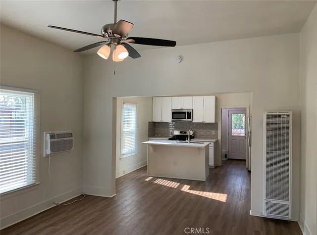 a kitchen with stainless steel appliances a stove top oven a sink a window and a counter space