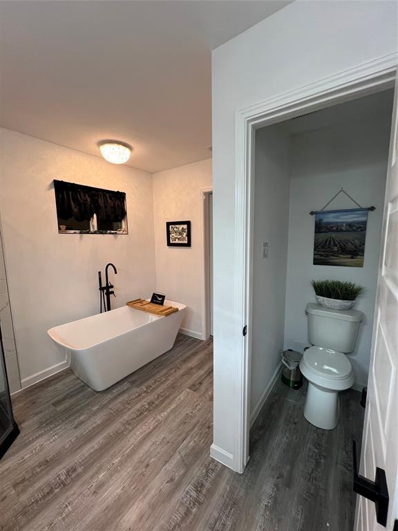 1202 Morrell Avenue Dallas, TX 75203 - Photo 24 of 33 a spacious bathroom with a toilet a sink and mirror