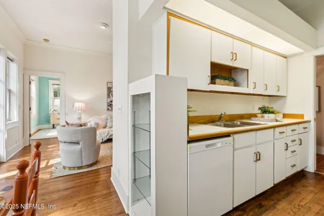 a kitchen with stainless steel appliances granite countertop a sink and dishwasher with white cabinets
