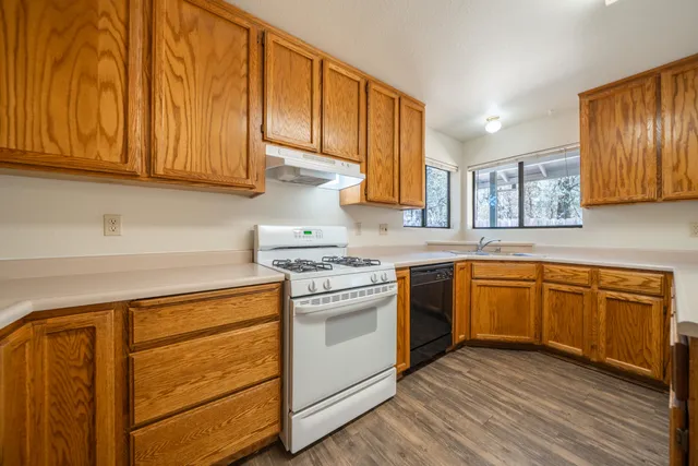 a kitchen with stainless steel appliances granite countertop a stove a sink dishwasher and a refrigerator