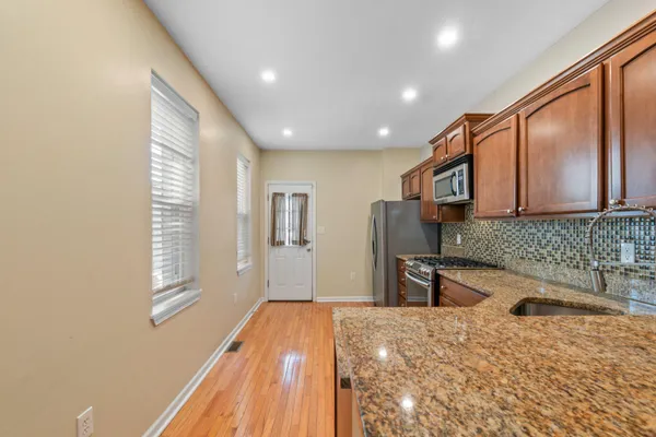 a kitchen with stainless steel appliances granite countertop a sink stove and refrigerator