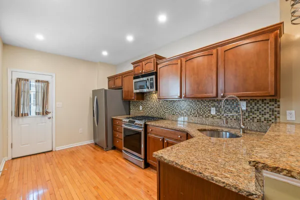 a kitchen with stainless steel appliances granite countertop a sink stove and refrigerator