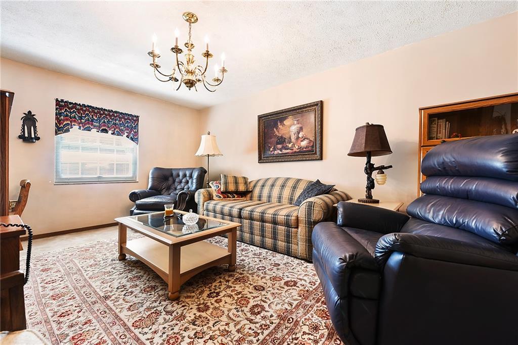 2850 Edgecliff Road, Unit 14 Lower Burrell, PA 15068 - Photo 13 of 24 a living room with furniture a chandelier and a window