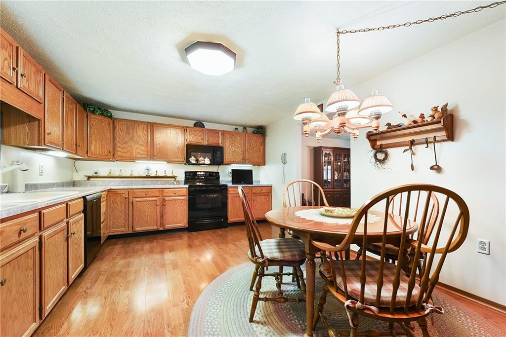 2850 Edgecliff Road, Unit 14 Lower Burrell, PA 15068 - Photo 6 of 24 a kitchen with a table chairs sink and cabinets