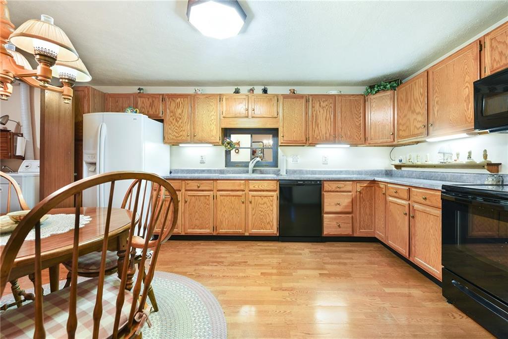 2850 Edgecliff Road, Unit 14 Lower Burrell, PA 15068 - Photo 7 of 24 a kitchen with stainless steel appliances granite countertop a stove top oven a sink dishwasher and white cabinets with wooden floor