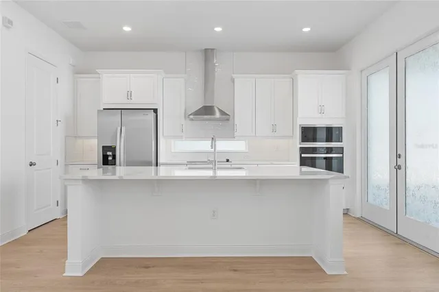 a kitchen with stainless steel appliances granite countertop a sink a stove and a refrigerator