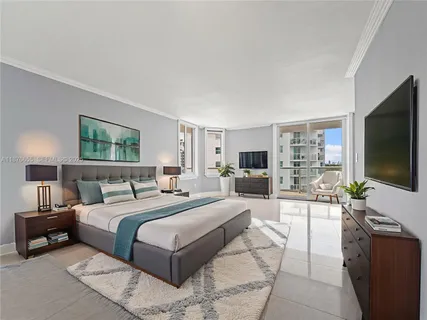 a bedroom with a large bed and a flat screen tv