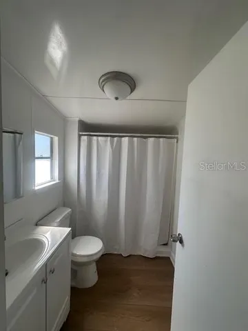a bathroom with a toilet a sink and a window