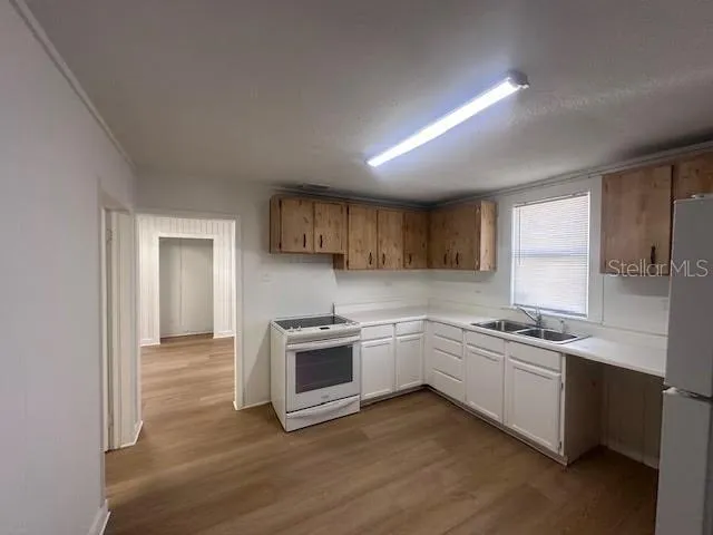 a kitchen with stainless steel appliances granite countertop a sink and cabinets with wooden floor