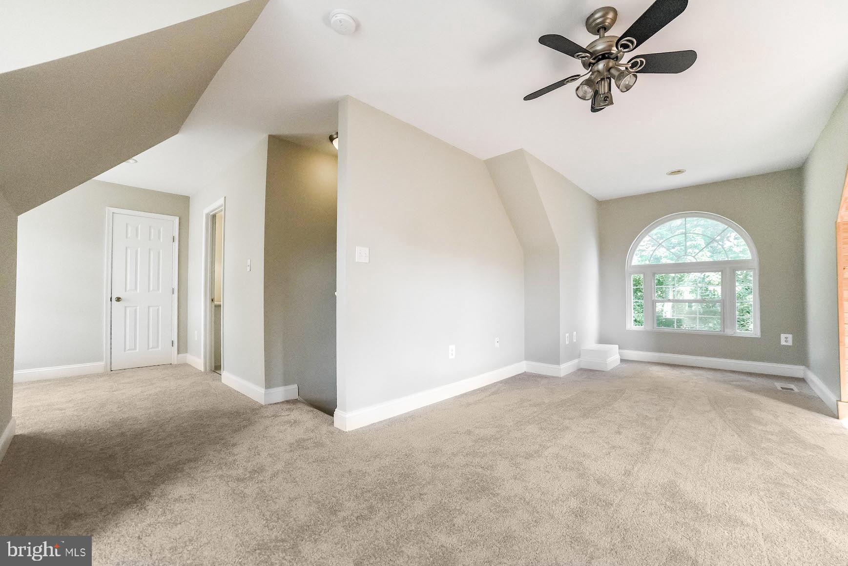 12756 Bullet Bend Road Lusby, MD 20657 - Photo 14 of 56 an empty room with windows and fan chandelier