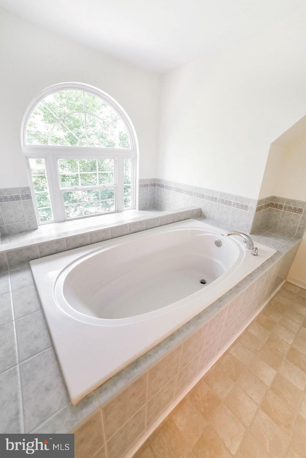 12756 Bullet Bend Road Lusby, MD 20657 - Photo 15 of 56 a white bath tub sitting in a bathroom next to a window
