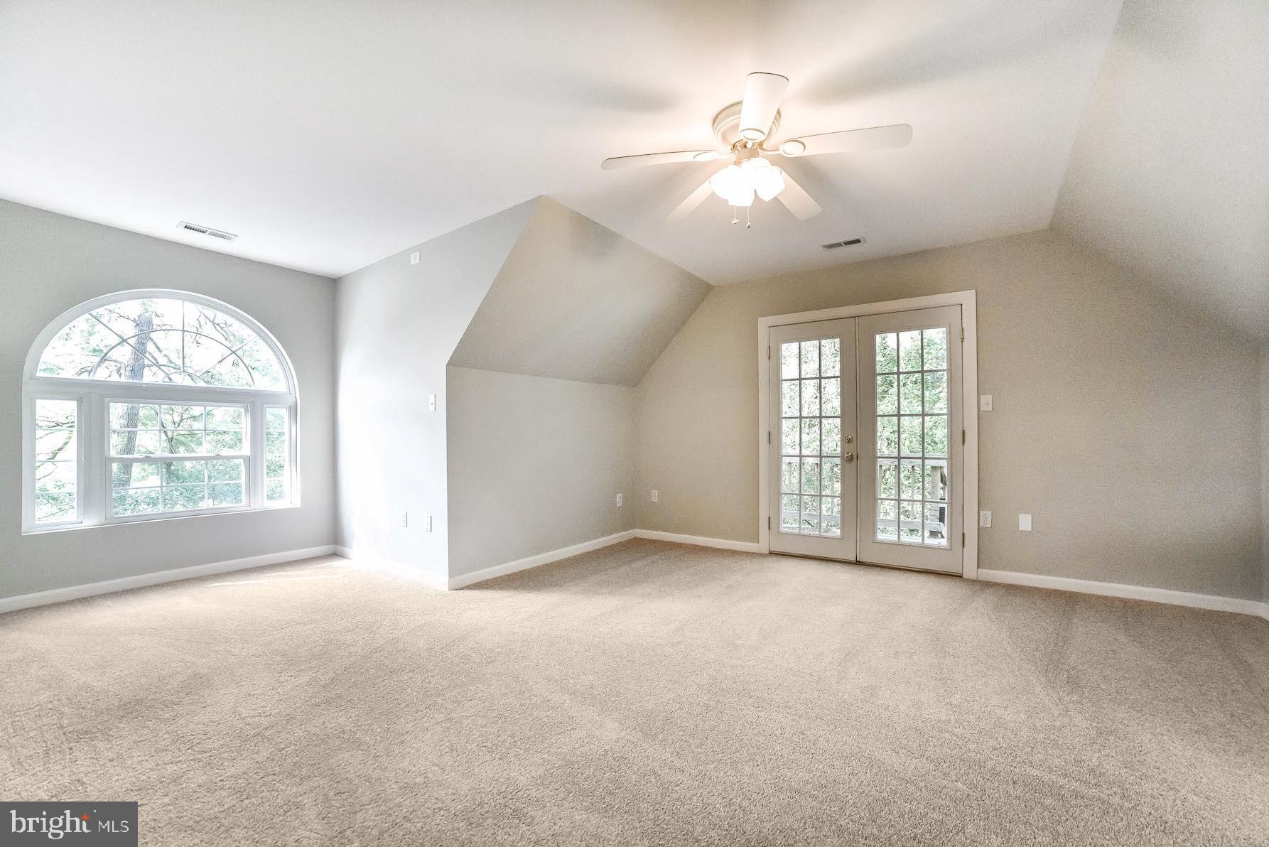 12756 Bullet Bend Road Lusby, MD 20657 - Photo 21 of 56 an empty room with windows and chandelier fan