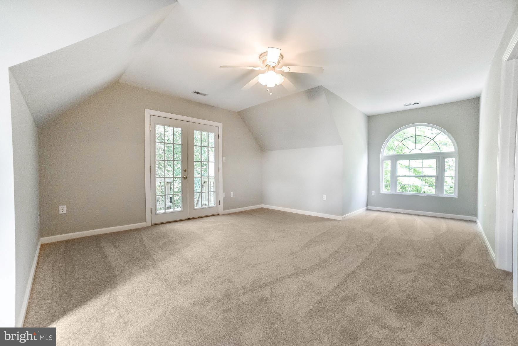12756 Bullet Bend Road Lusby, MD 20657 - Photo 22 of 56 an empty room with windows and chandelier fan
