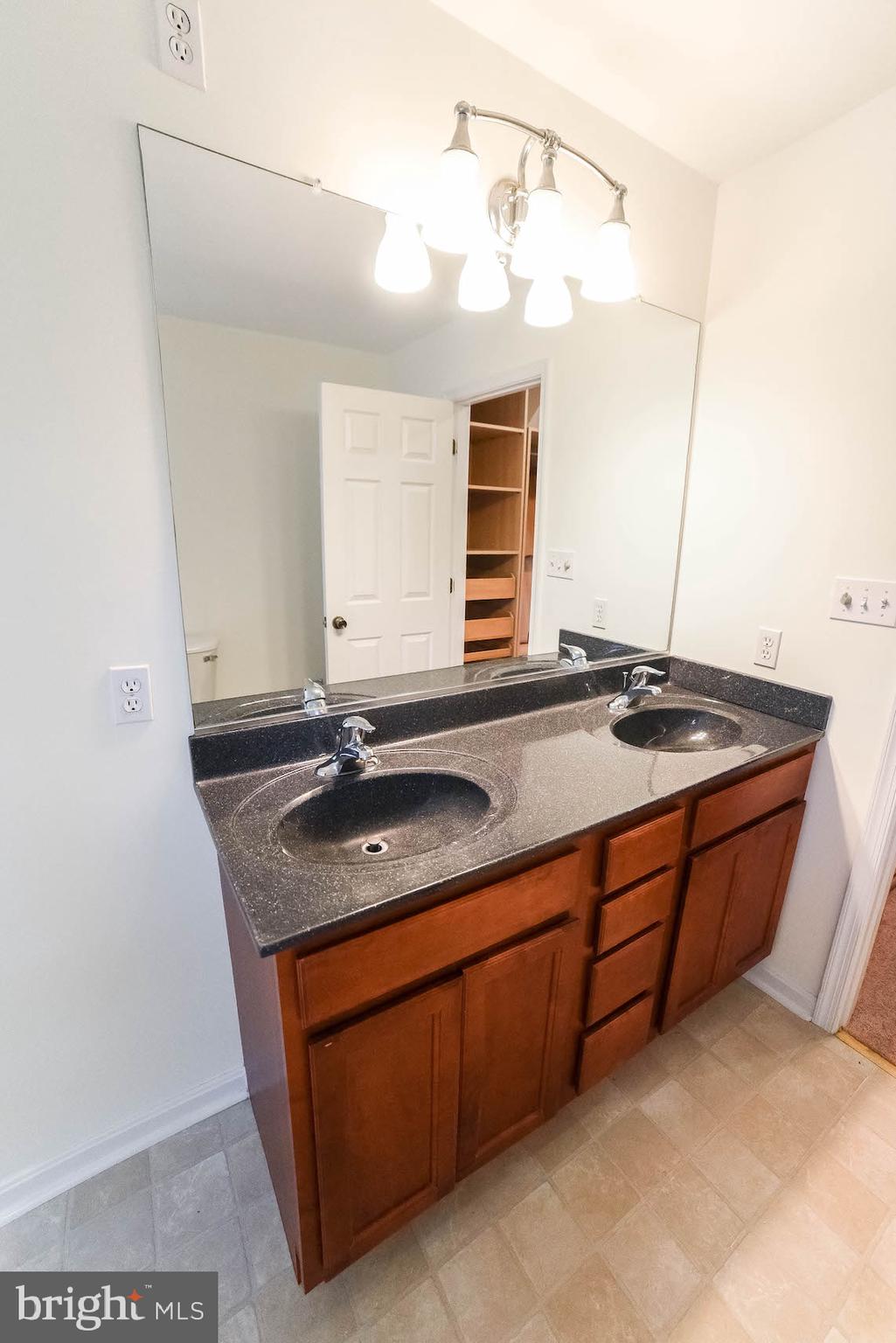 12756 Bullet Bend Road Lusby, MD 20657 - Photo 29 of 56 a bathroom with a granite countertop sink and a mirror
