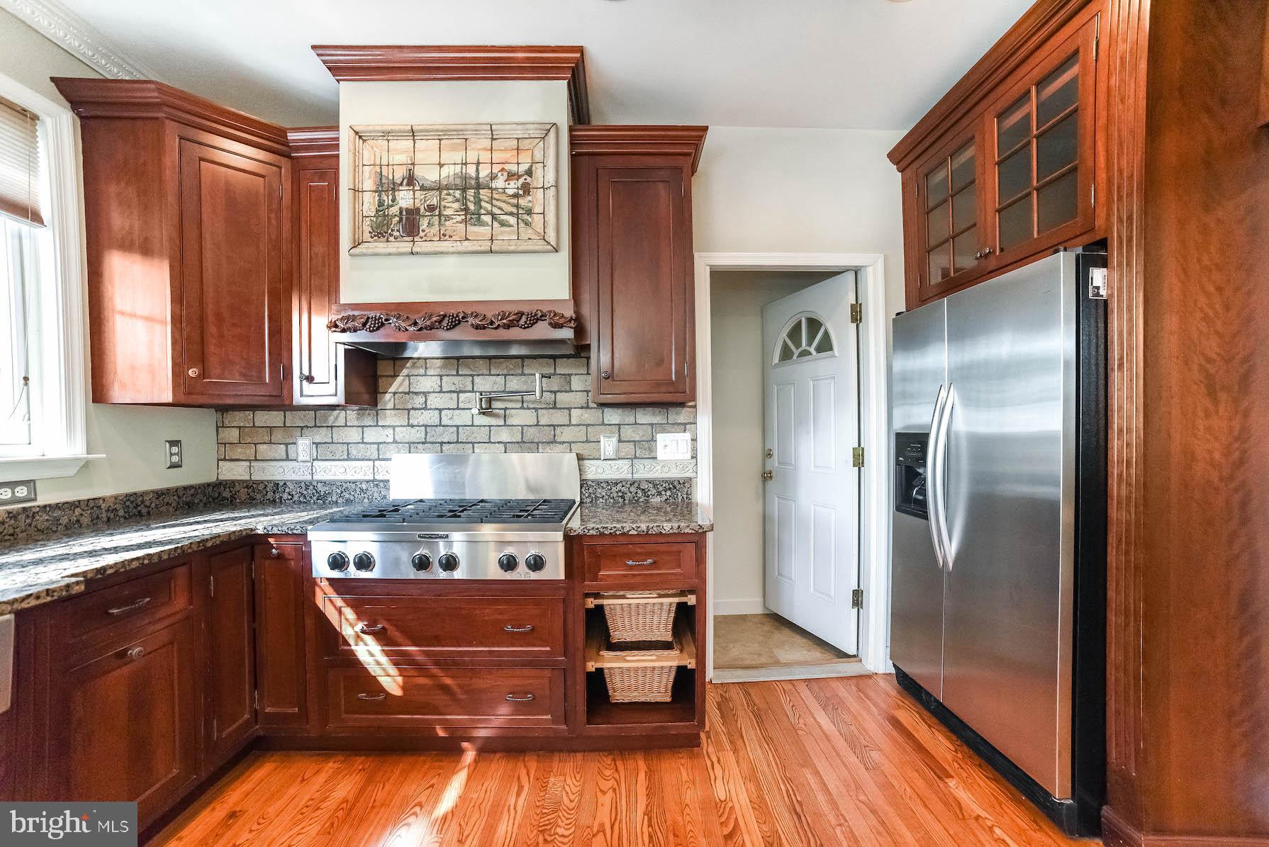 12756 Bullet Bend Road Lusby, MD 20657 - Photo 40 of 56 a kitchen with stainless steel appliances granite countertop a refrigerator a sink and wooden cabinets