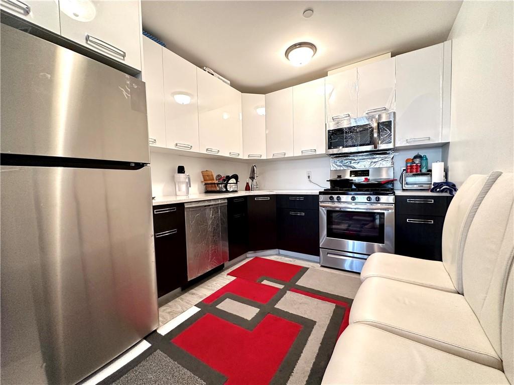 3016 Brighton 5th Street, Unit 1A Brooklyn, NY 11235 - Photo 5 of 15 a kitchen with stainless steel appliances granite countertop a refrigerator sink and stove