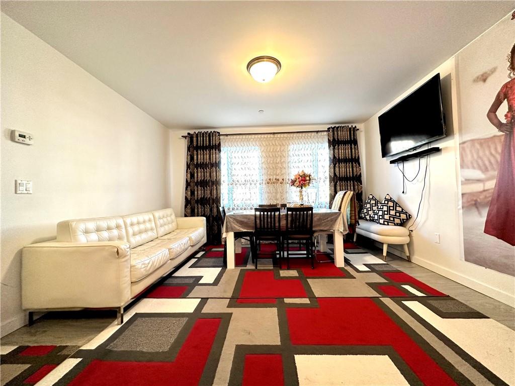 3016 Brighton 5th Street, Unit 1A Brooklyn, NY 11235 - Photo 8 of 15 a living room with furniture and a flat screen tv