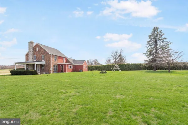 a view of an house with backyard space and trampoline