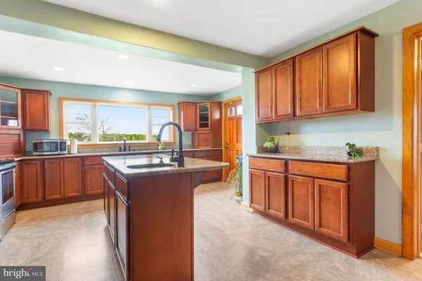 a kitchen with stainless steel appliances granite countertop sink stove and refrigerator